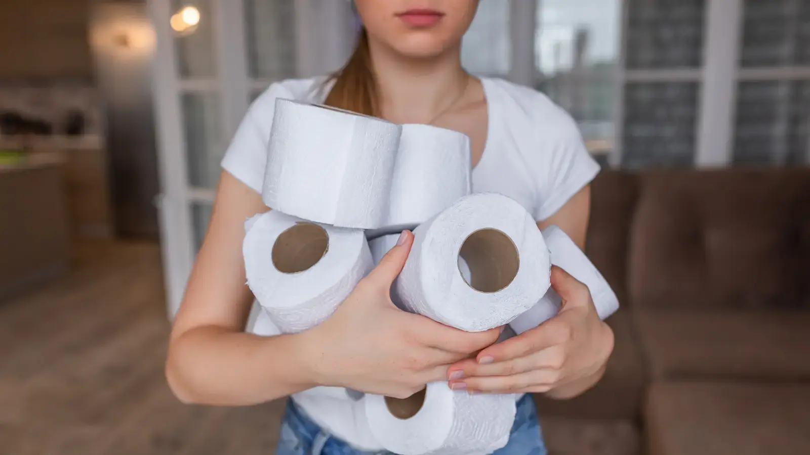 O femeie transformă o sticlă goală de detergent într-un suport drăguț pentru hârtia de toaletă